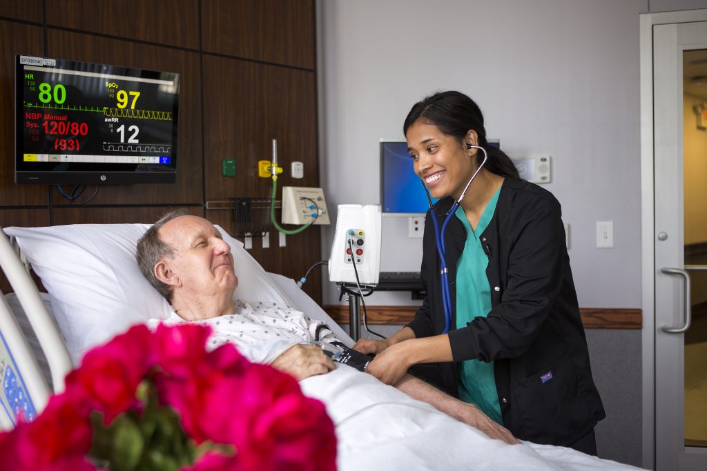 A nurse caring for a patient in a hospital room